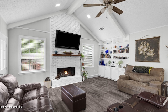 living area with dark wood-style flooring, a ceiling fan, a brick fireplace, and a textured ceiling