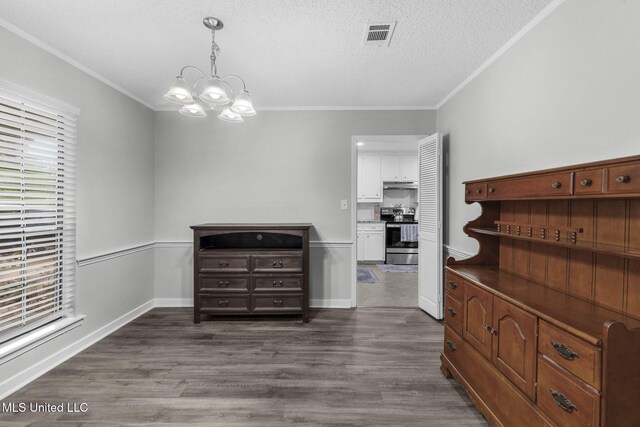 dining room with a chandelier, dark wood-style flooring, a textured ceiling, crown molding, and baseboards