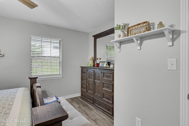 bedroom with a textured ceiling and light wood-type flooring