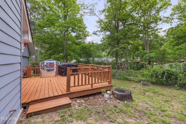 wooden terrace with grilling area, a fenced backyard, a fire pit, and view of wooded area