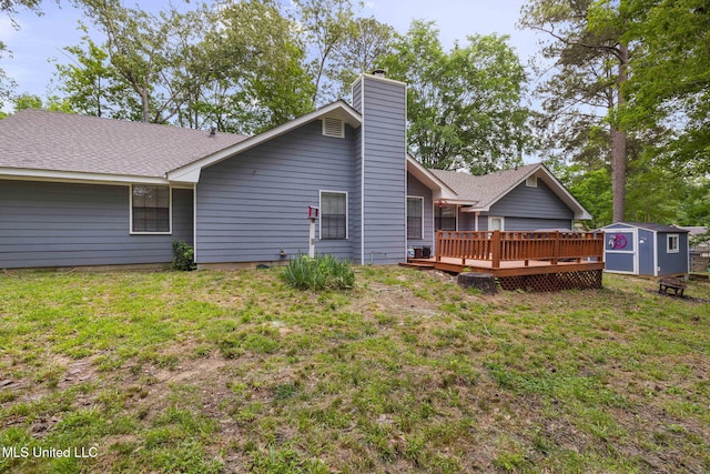 rear view of house featuring a storage unit, a deck, an outdoor structure, and a yard