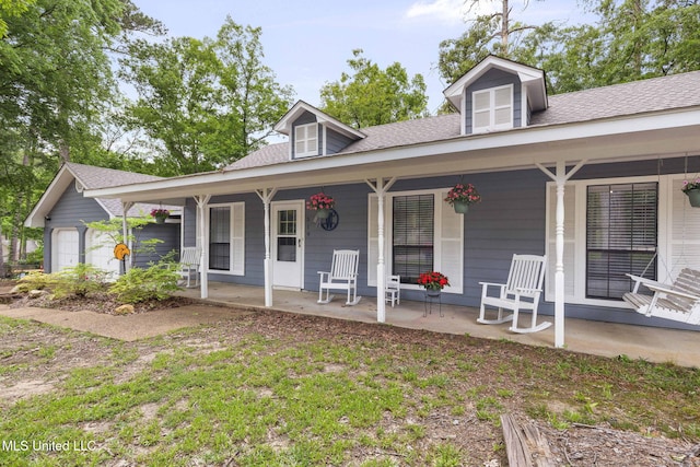 view of front of house featuring covered porch and a shingled roof