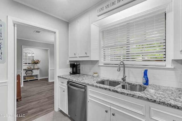 kitchen with dishwasher, a textured ceiling, a sink, crown molding, and white cabinetry