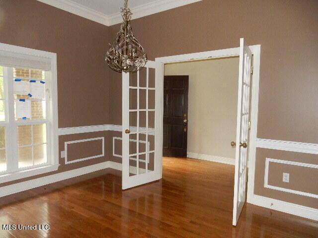 8 Auburn Ln, Hattiesburg, MS 39401 - unfurnished dining area with french doors, wood finished floors, crown molding, baseboards, and plenty of natural light
