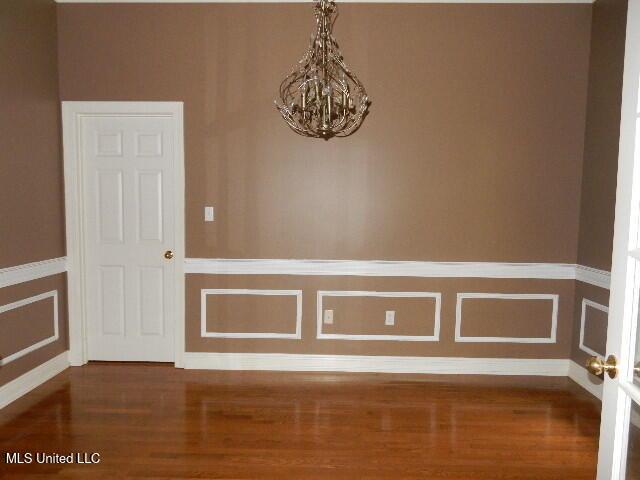 8 Auburn Ln, Hattiesburg, MS 39401 - empty room with a chandelier, wood finished floors, and baseboards