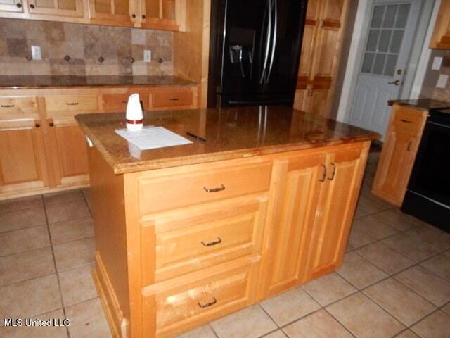 8 Auburn Ln, Hattiesburg, MS 39401 - kitchen with black appliances, a center island, light tile patterned floors, and decorative backsplash