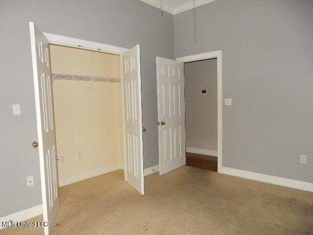 8 Auburn Ln, Hattiesburg, MS 39401 - unfurnished bedroom with carpet flooring, a closet, ornamental molding, baseboards, and attic access