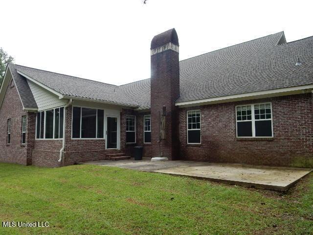 8 Auburn Ln, Hattiesburg, MS 39401 - rear view of house featuring brick siding, a patio, a lawn, a chimney, and a shingled roof