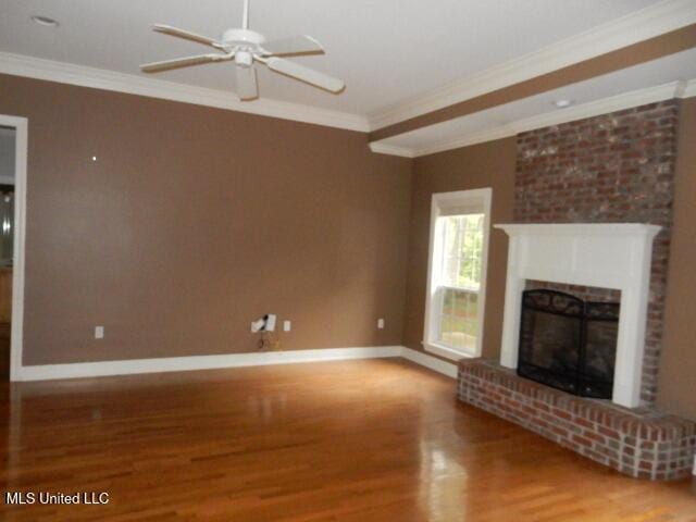 8 Auburn Ln, Hattiesburg, MS 39401 - unfurnished living room with wood finished floors, ornamental molding, baseboards, ceiling fan, and a fireplace