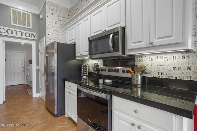 408 Abbey Woods, Brandon, MS 39047 - kitchen with stainless steel appliances, crown molding, a high ceiling, dark countertops, and washer and dryer