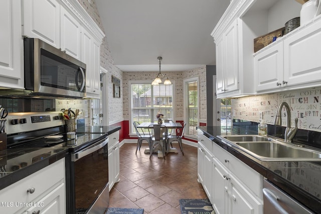 408 Abbey Woods, Brandon, MS 39047 - kitchen featuring stainless steel appliances, a sink, white cabinets, dark countertops, and wallpapered walls