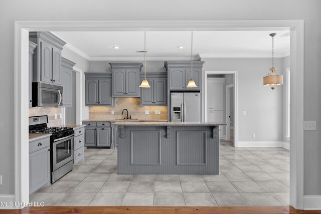 kitchen with gray cabinets, backsplash, a center island, a sink, and stainless steel appliances
