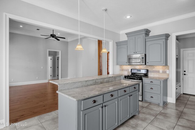 kitchen featuring a center island, stainless steel appliances, backsplash, gray cabinetry, and ornamental molding