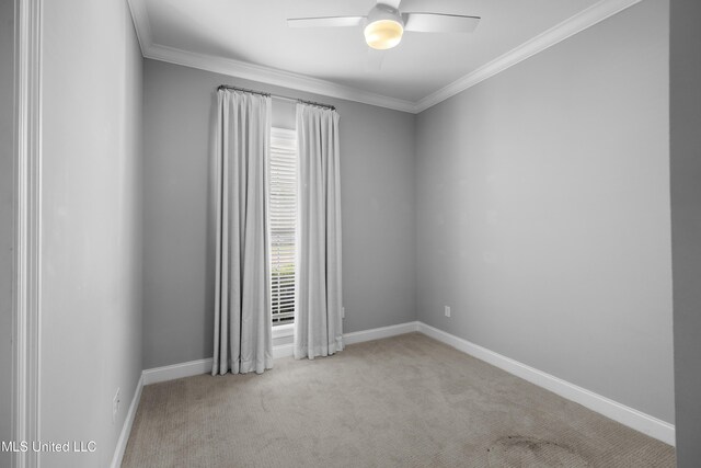 carpeted spare room with crown molding, a ceiling fan, and baseboards