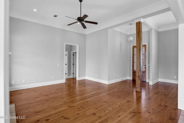 spare room featuring baseboards, crown molding, ceiling fan, and hardwood / wood-style floors