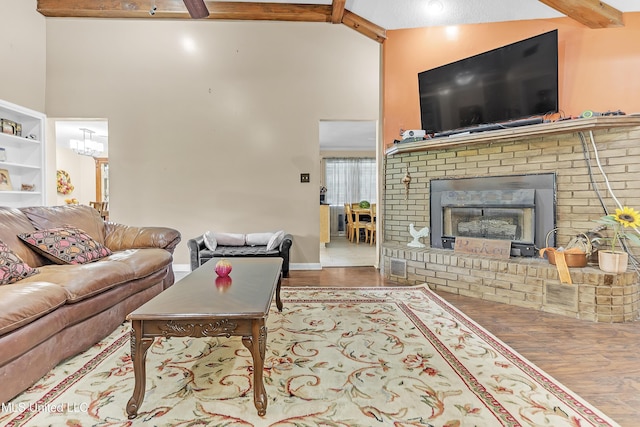 231 Hickory Ln, Batesville, MS 38606 - living area with wood finished floors, beam ceiling, a high ceiling, baseboards, and a brick fireplace