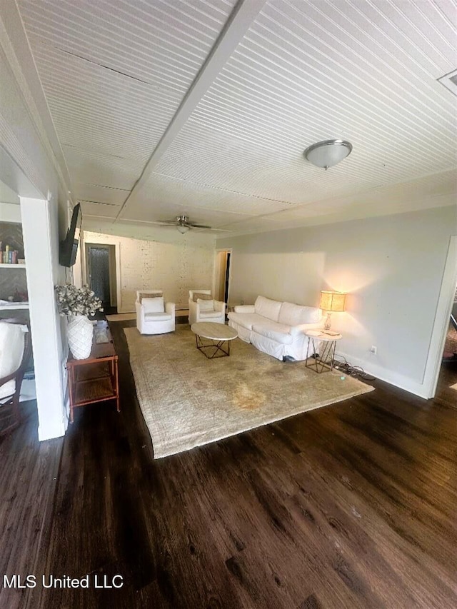 unfurnished living room with ceiling fan and dark wood-type flooring