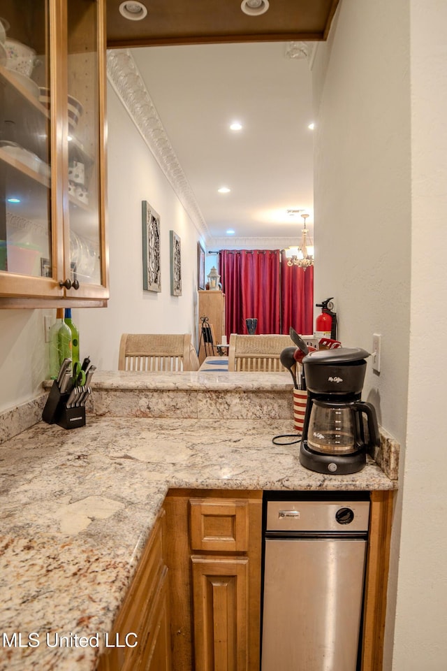 kitchen featuring recessed lighting, glass insert cabinets, brown cabinetry, light stone countertops, and a peninsula