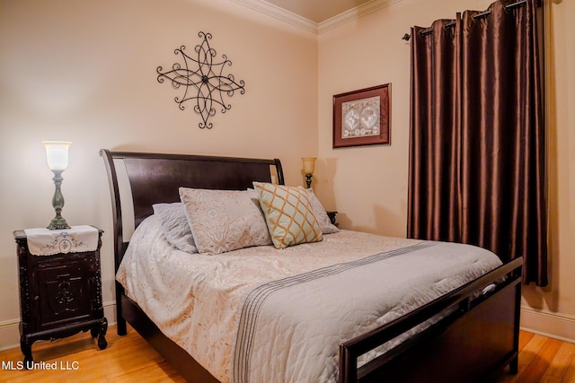 bedroom with baseboards, light wood-type flooring, and crown molding