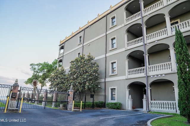 view of property featuring fence and uncovered parking