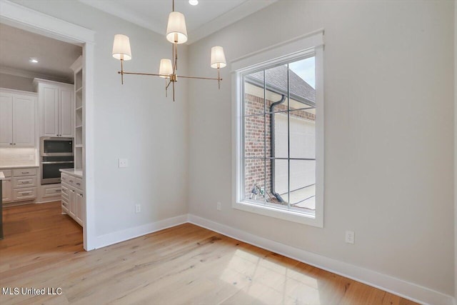 unfurnished dining area with crown molding and light wood-type flooring