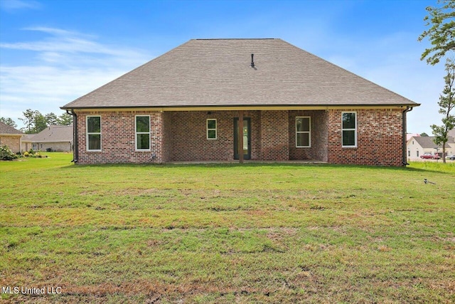 rear view of house featuring a yard