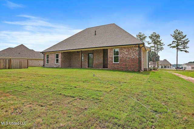 back of property featuring a yard