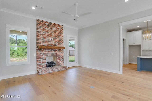 unfurnished living room with crown molding, light wood-type flooring, a fireplace, and ceiling fan