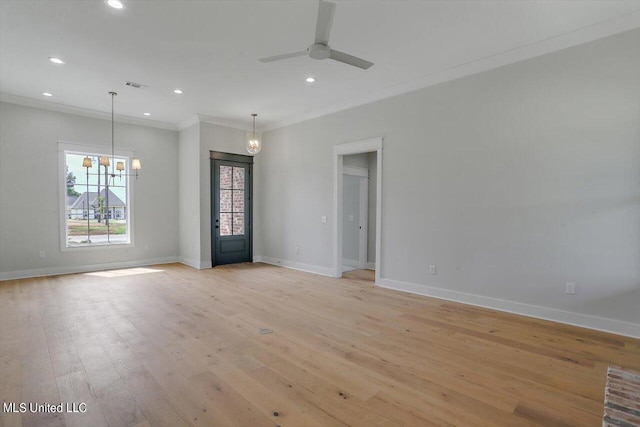 spare room with ornamental molding, light hardwood / wood-style flooring, and ceiling fan with notable chandelier