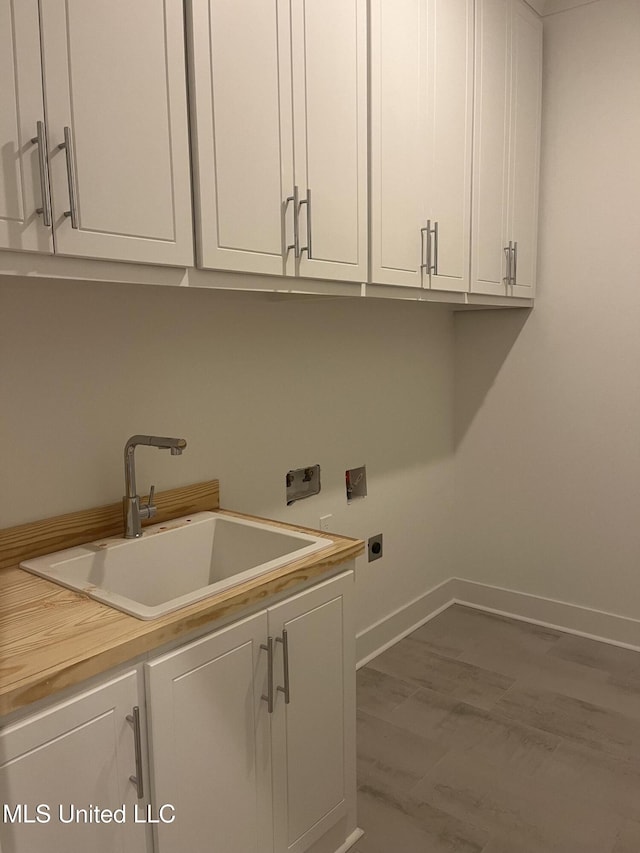 washroom featuring hardwood / wood-style floors, sink, cabinets, and hookup for an electric dryer