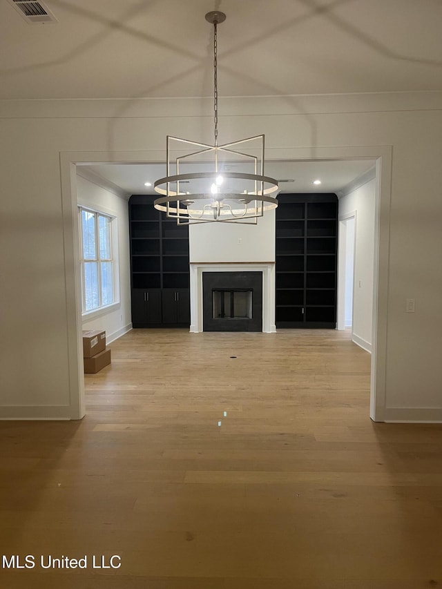 unfurnished living room featuring crown molding and hardwood / wood-style floors