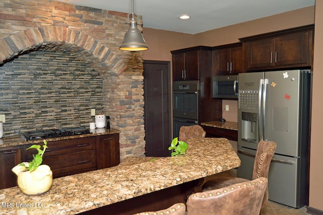 1088 S Red Banks Rd, Byhalia, MS 38611 - kitchen featuring black appliances, dark brown cabinets, decorative backsplash, a breakfast bar, and light stone counters