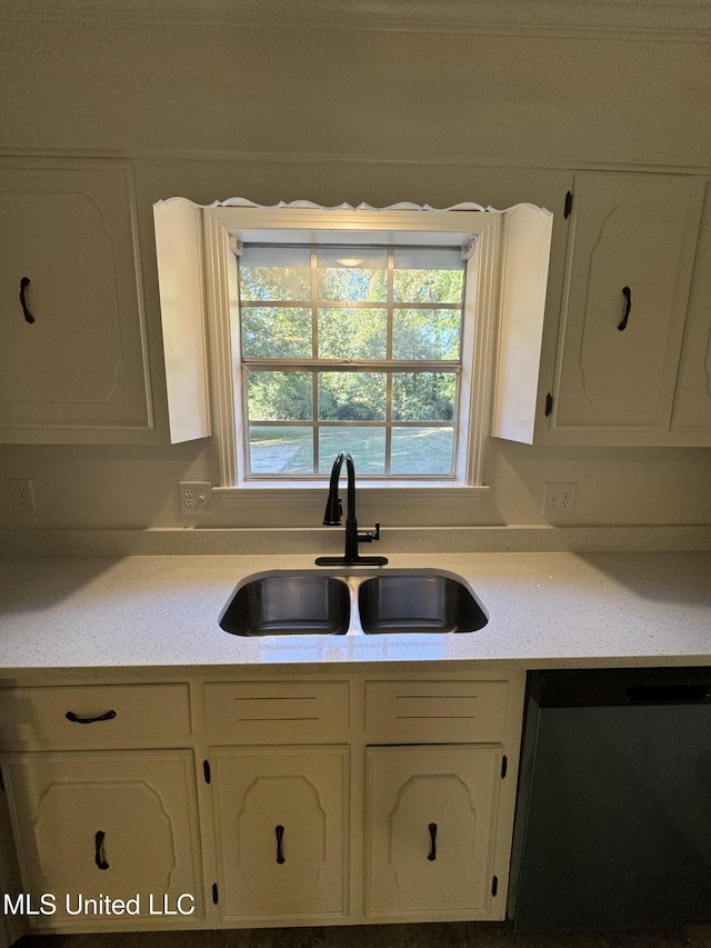 kitchen featuring white cabinets, stainless steel dishwasher, and sink