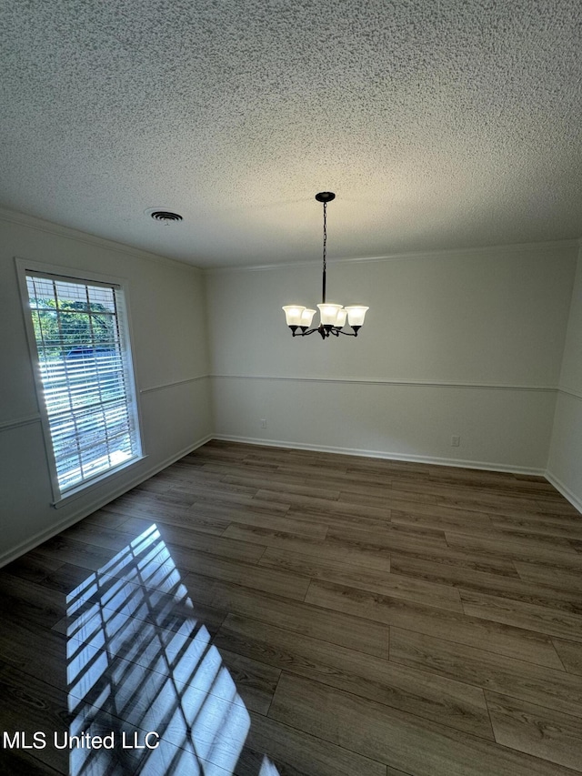 unfurnished dining area featuring a chandelier, dark hardwood / wood-style floors, and a textured ceiling