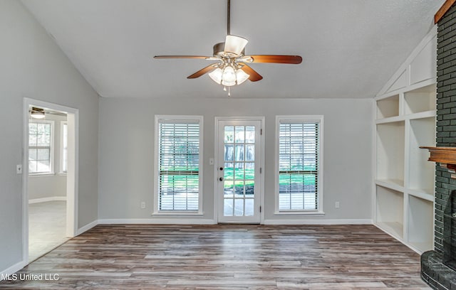 118 Bellegrove Blvd, Brandon, MS 39047 - unfurnished living room featuring a brick fireplace, lofted ceiling, a wealth of natural light, and ceiling fan