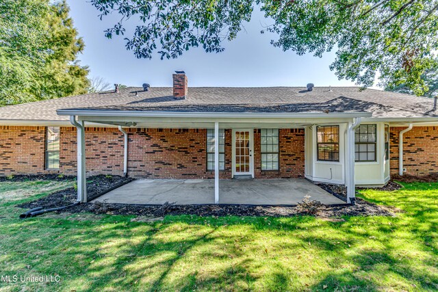 118 Bellegrove Blvd, Brandon, MS 39047 - back of property with a shingled roof, brick siding, a chimney, a patio area, and a lawn