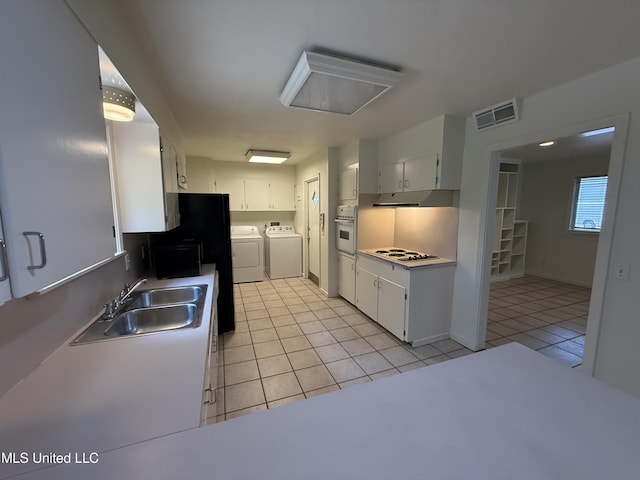1632 Winchester St, Jackson, MS 39211 - kitchen with independent washer and dryer, a sink, white appliances, light tile patterned floors, and under cabinet range hood
