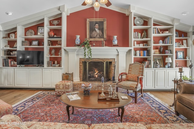 2629 Park View Dr, Biloxi, MS 39531 - living area featuring wood finished floors, built in features, vaulted ceiling, a ceiling fan, and a fireplace