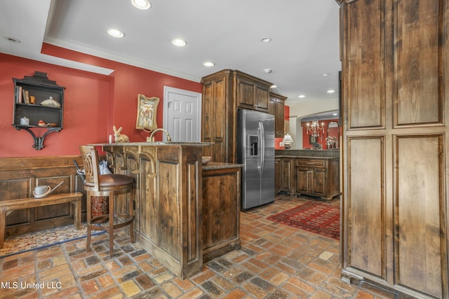 2629 Park View Dr, Biloxi, MS 39531 - kitchen with stainless steel fridge, brick flooring, crown molding, a breakfast bar, and recessed lighting
