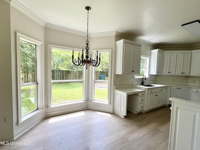 kitchen featuring light countertops, a chandelier, crown molding, and healthy amount of natural light