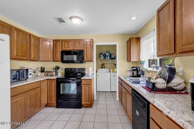 615 Baker St, Wiggins, MS 39577 - kitchen with black appliances, a sink, independent washer and dryer, light tile patterned flooring, and brown cabinetry