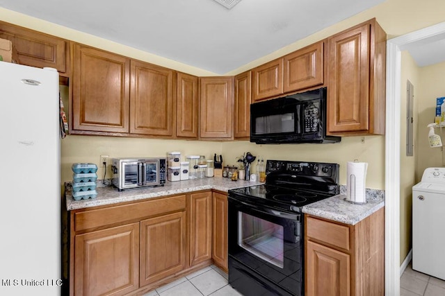 615 Baker St, Wiggins, MS 39577 - kitchen featuring black appliances, washer / dryer, light tile patterned flooring, brown cabinetry, and light stone counters