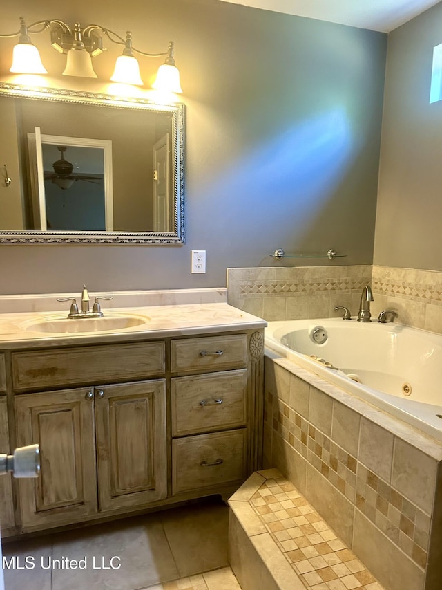 bathroom with tile patterned flooring, a jetted tub, a ceiling fan, and vanity