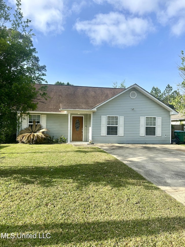 ranch-style home featuring a front yard and concrete driveway