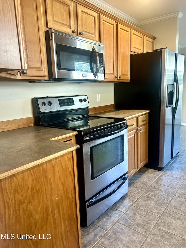 kitchen featuring ornamental molding, light tile patterned flooring, and appliances with stainless steel finishes