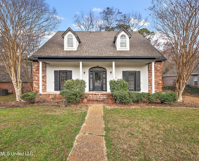 view of front of house featuring a shingled roof, a front yard, and stucco siding