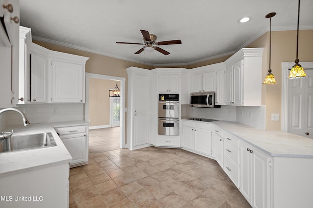 kitchen with crown molding, stainless steel appliances, a ceiling fan, a sink, and a peninsula