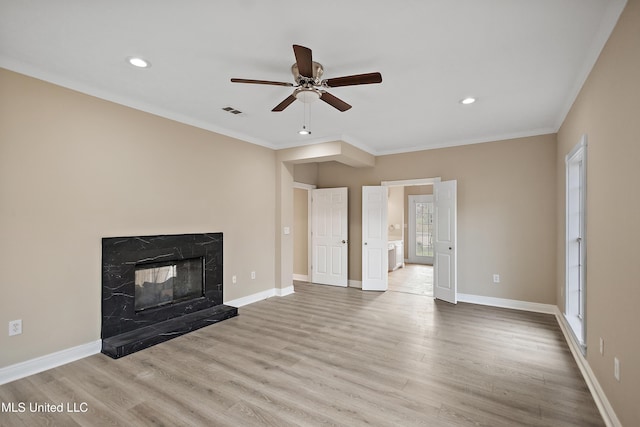 unfurnished living room featuring baseboards, ornamental molding, wood finished floors, and a high end fireplace