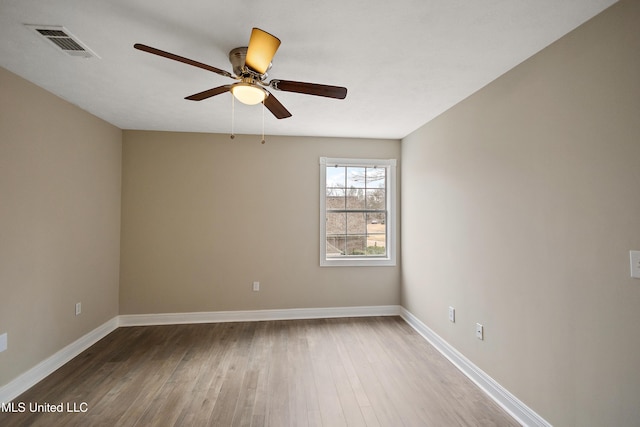 unfurnished room featuring visible vents, ceiling fan, baseboards, and wood finished floors