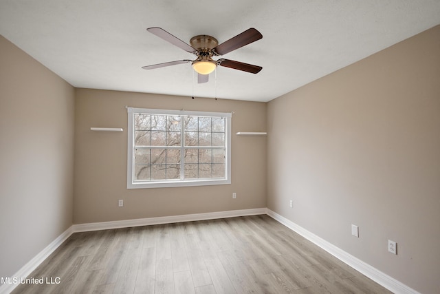 spare room featuring a ceiling fan, baseboards, and wood finished floors